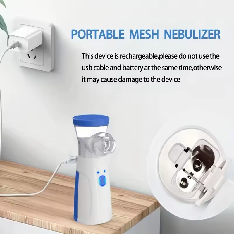Portable mesh nebulizer on wooden table plugged into power outlet, close-up of device interior